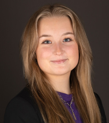 En kvinna med långt blont hår som bär en svart jacka