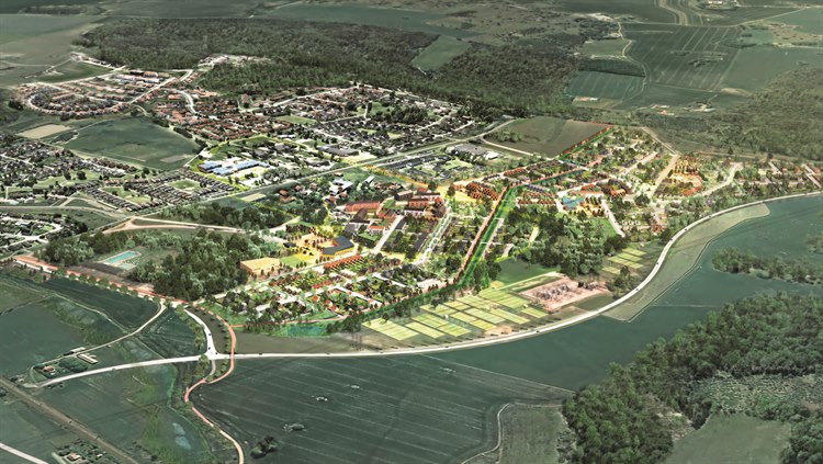 Visionsbild visar en översiktsvy av ett planeradbebyggelse. Området är beläget i en grönskande miljö med skogar och ängar