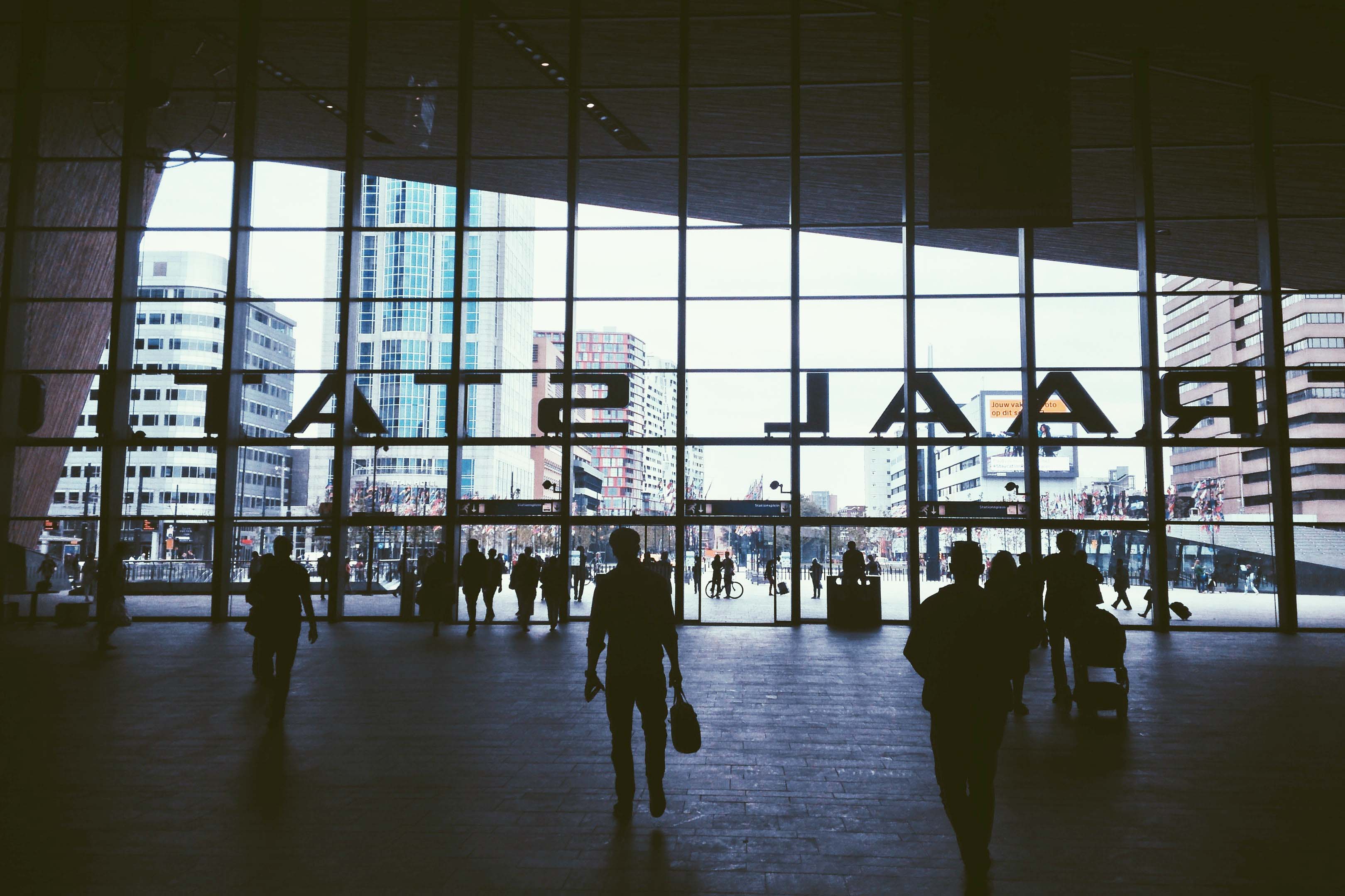 Siluetter av människor som går ut och in från en reseterminal