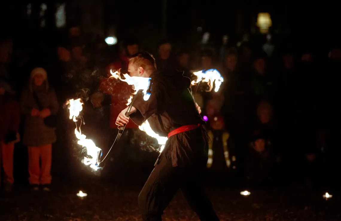 En man håller en eldstav framför en folkmassa