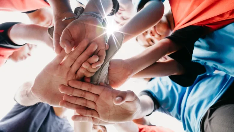 En grupp människor som håller varandra i handen i en cirkel.