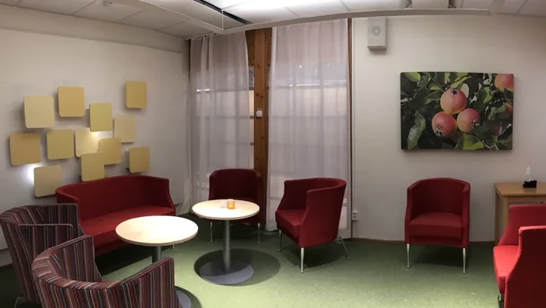 Ett rum med stolar, ett bord och en tavla på väggen