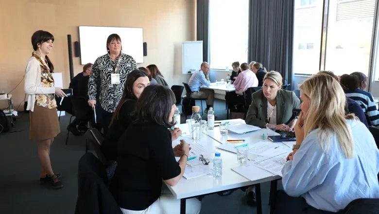 A photo of the participants during a workshop, discussions by the tables
